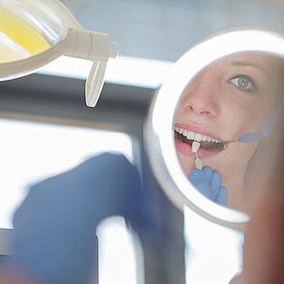 Patientin beim Zahnarzt im Behandlungsspiegel